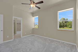 Unfurnished bedroom with carpet floors, ensuite bathroom, and ceiling fan