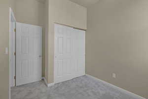 Unfurnished bedroom featuring carpet and a closet