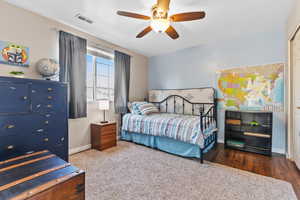 Carpeted bedroom featuring a ceiling fan and baseboards