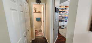 Hallway with dark wood-style floors and baseboards