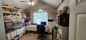 Office area with a ceiling fan and vaulted ceiling