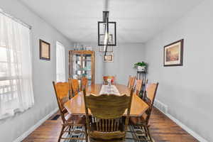 Dining space featuring wood finished floors and a chandelier