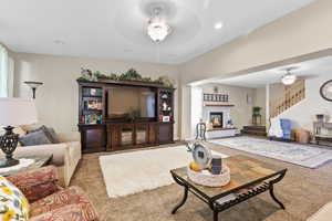 Carpeted living area featuring a ceiling fan, a glass covered fireplace, and recessed lighting