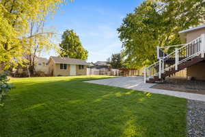 View of yard featuring stairway, a deck, and an outdoor structure
