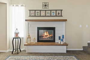 Detailed view of carpet floors and a glass covered fireplace
