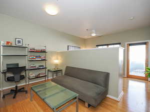 Living area with light wood finished floors, baseboards, and ceiling fan