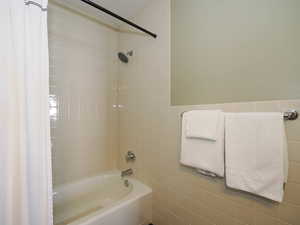 Full bathroom with tile walls and bathtub / shower combination