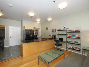 Living area featuring an office area, light wood-style flooring, and baseboards