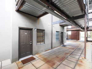 Entrance to property featuring stucco siding and a patio area