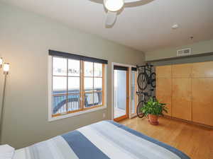 Bedroom with access to outside, wood finished floors, and a ceiling fan