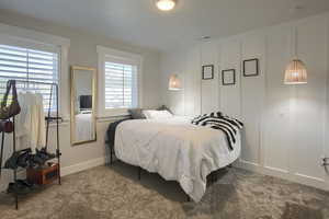Bedroom featuring carpet and baseboards
