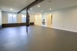 Unfurnished room with finished concrete floors, recessed lighting, and arched walkways