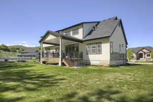 Back of property with stucco siding, roof with shingles, and a wooden deck