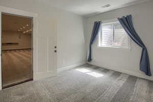 Empty room featuring carpet flooring and baseboards