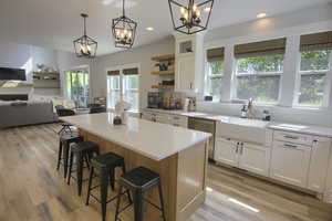 Kitchen featuring a chandelier, stainless steel dishwasher, decorative backsplash, open shelves, and recessed lighting