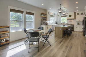 Dining area with light wood-style flooring, a chandelier, and recessed lighting