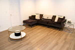 Living area with wood finished floors and baseboards