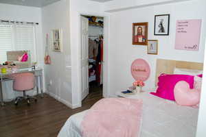 Bedroom featuring wood finished floors, a closet, and a spacious closet