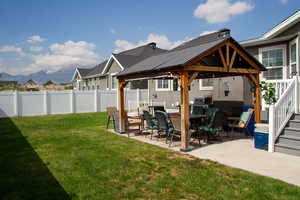 Fenced backyard with a gazebo, a patio area, and a mountain view