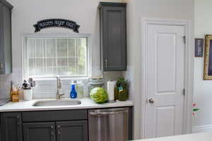 Bar featuring stainless steel dishwasher and backsplash