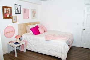 Bedroom featuring wood finished floors and baseboards
