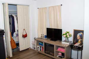 Bedroom with wood finished floors and a closet