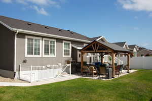 Rear view of house with a gazebo, a patio, and stucco siding