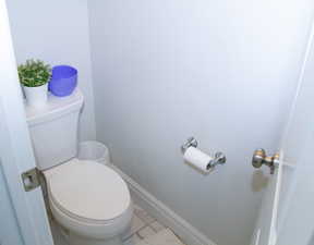Bathroom with toilet and marble finish floors