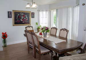 Dining space with wood finished floors and a chandelier