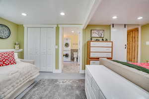 Bedroom featuring stacked washing machine and dryer, recessed lighting, and a closet