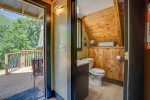 Bathroom featuring tile patterned floors and vaulted ceiling