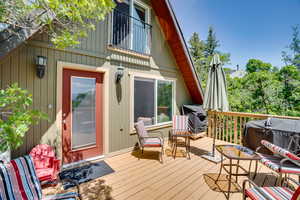 Wooden terrace featuring a grill