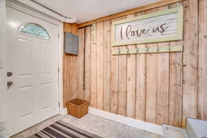 Mudroom featuring wood walls and electric panel