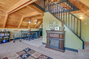 Stairway featuring carpet, wooden ceiling, and lofted ceiling