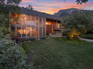 Back of property with a lawn and a mountain view