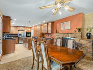 Dining room with ceiling fan, light tile patterned floors, recessed lighting, and light carpet