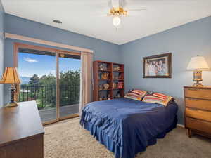 Bedroom with access to outside, carpet floors, and a ceiling fan