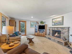 Living area with a stone fireplace and light colored carpet