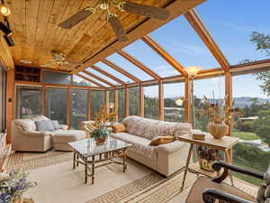 Sunroom featuring a ceiling fan, an outdoor hangout area, and a mountain view