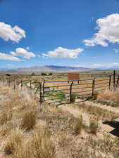 View of yard featuring a rural view, a gate, and a mountain view