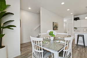 Dining area with light wood-style floors and recessed lighting