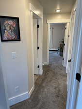 Corridor featuring carpet and baseboards