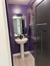 Bathroom featuring a textured ceiling and wood finished floors