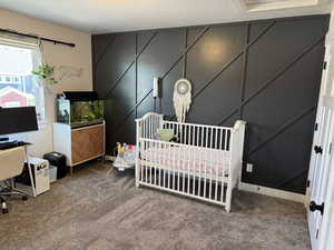 Bedroom with carpet floors and a crib