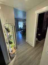 Hall featuring light wood finished floors and a textured ceiling