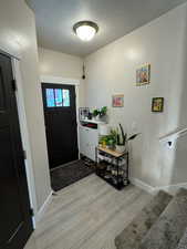 Entrance foyer featuring light wood-type flooring and a textured ceiling