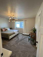 Bedroom featuring carpet floors, a chandelier, and a textured ceiling