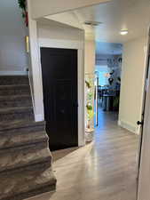 Entryway with stairs, a textured ceiling, and light wood finished floors