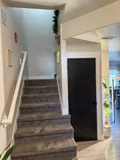 Stairway featuring wood finished floors and baseboards