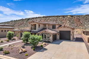 Mediterranean / spanish house featuring stucco siding, a garage, a mountain view, driveway, and a tile roof